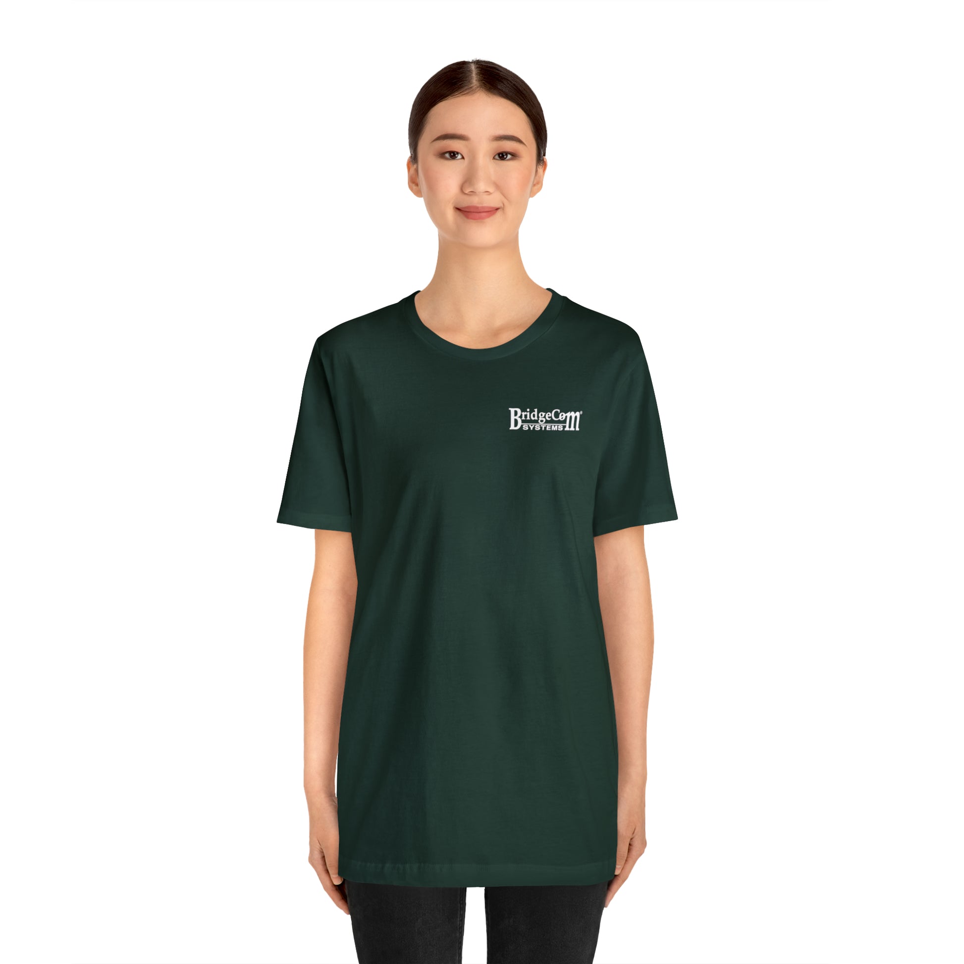 A person with tied-back hair is wearing a dark green Short Sleeve Tee - Small Logo made of Airlume combed cotton, with "Bridgestar Developers" printed in white text on the upper left side. The person is standing and smiling against a plain white background.