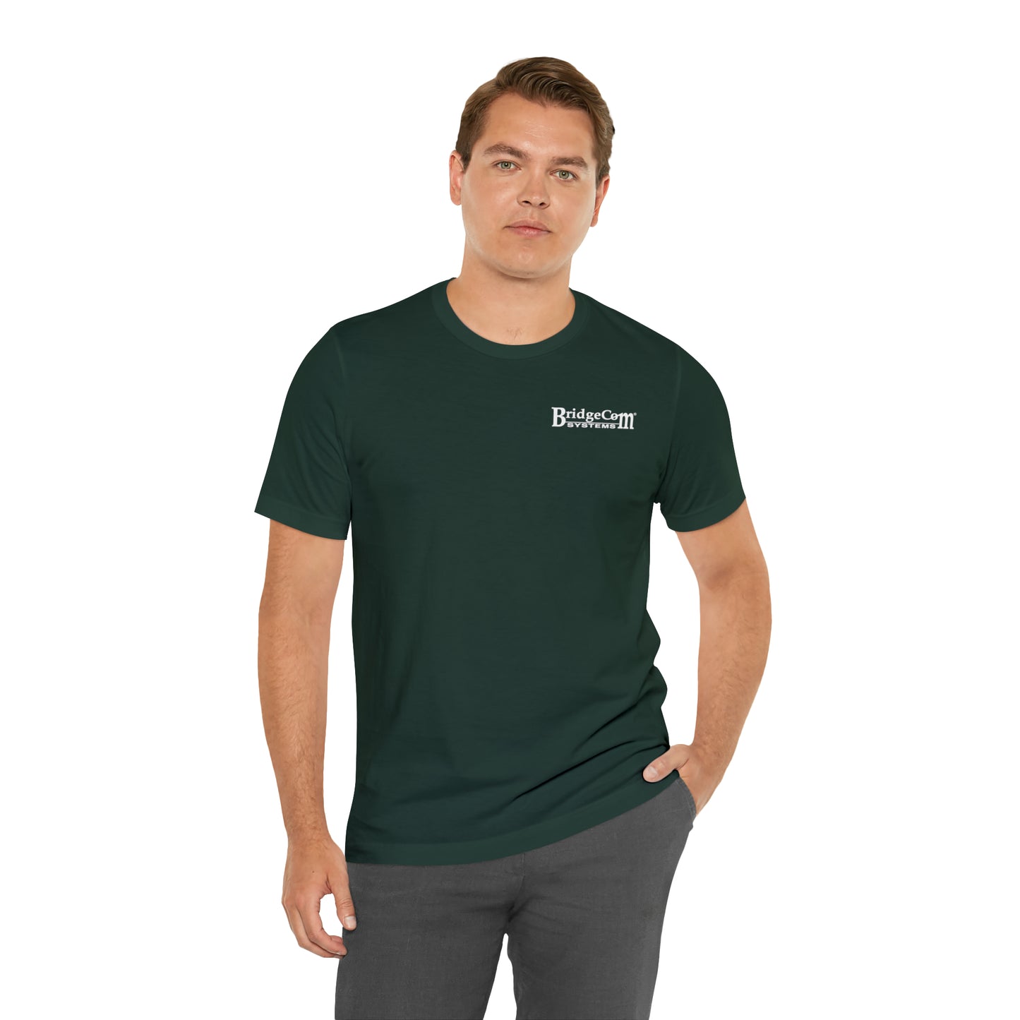 A man stands with one hand in his pocket, wearing the "Short Sleeve Tee - Small Logo" in dark green, made from Airlume cotton with the text "BridgeCiti Properties" on the left chest area. He has short hair and is facing the camera against a plain white background.