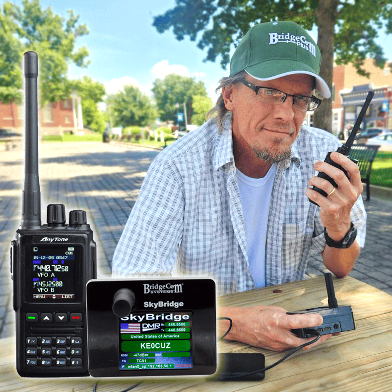 A man in a green cap and glasses sits outdoors, holding the AT-D168UV Plug and Play Package. In the foreground are a digital radio and a SkyBridge digital hotspot, both displaying radio information on their screens.