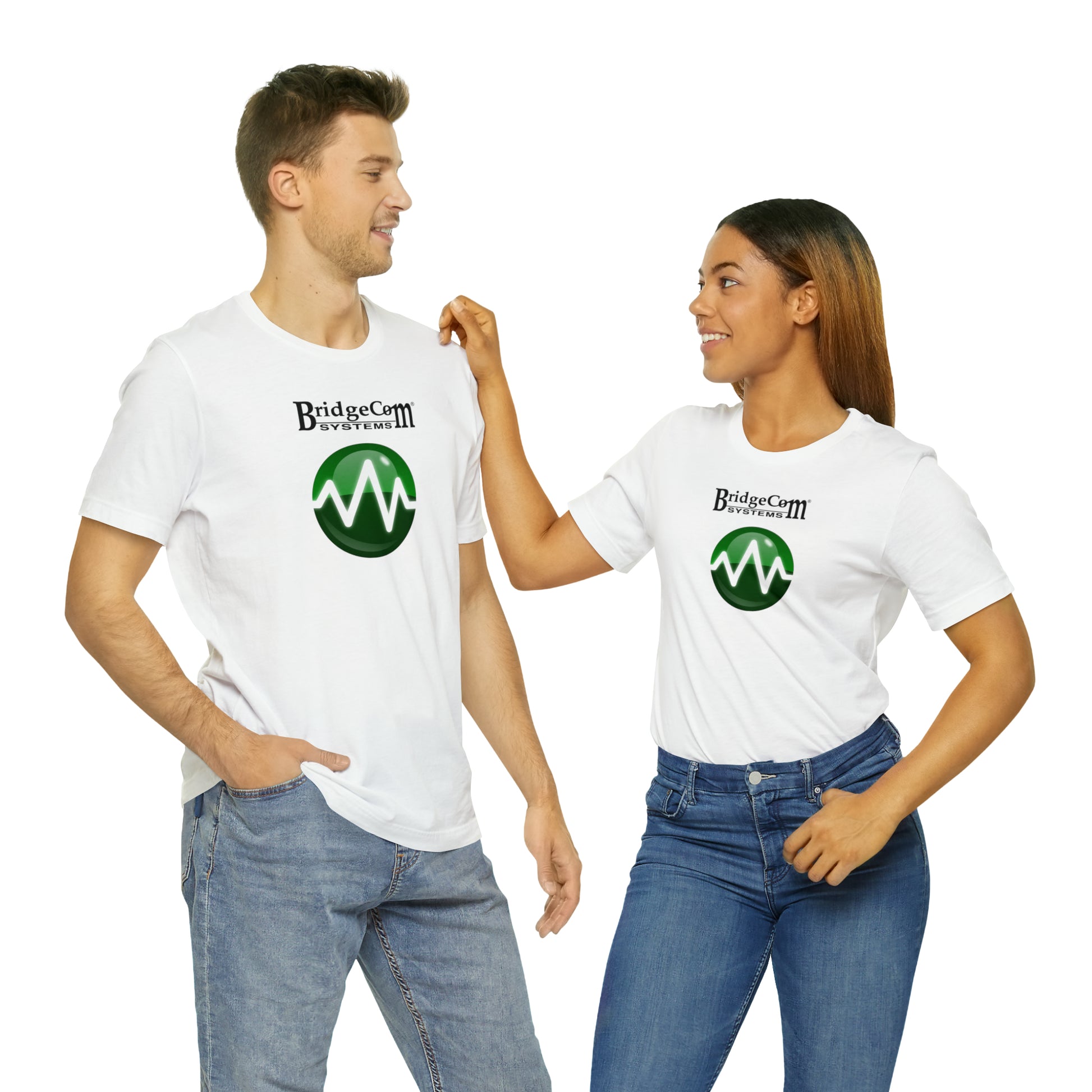 A man and a woman stand smiling at each other, both wearing Unisex Short Sleeve BridgeCom Tees adorned with a green and black logo that says "Bridge Comms" above a stylized green wave inside a green circle. The man has his hands in his pockets, relishing the comfort of the Airlume cotton fabric.