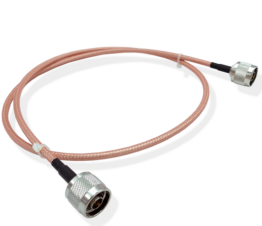 Introducing the 3' RG142 N-Male to N-Male Jumper Cable, featuring pinkish outer insulation and metallic N-Male connectors on both ends. The cable is neatly coiled with a plastic cable tie in the middle, making it ideal for RF applications. It is set against a plain white background.