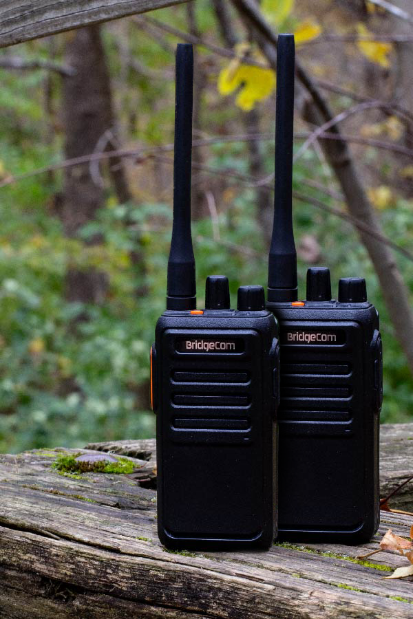 Pair of Echo radios on a log in forest