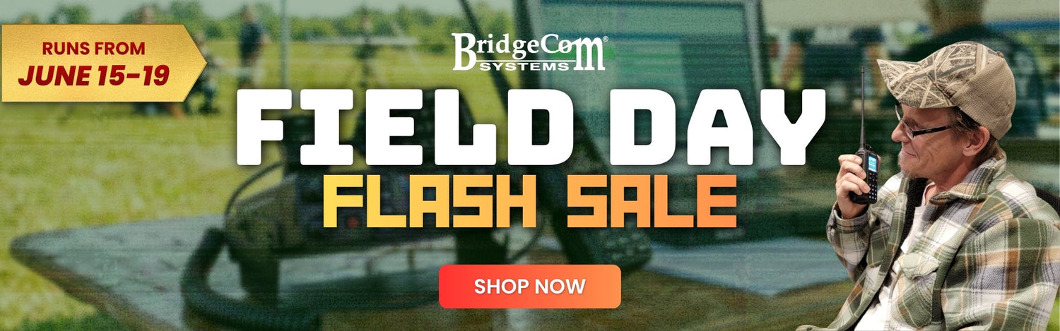 BridgeCom Systems Field Day Flash Sale banner; man in camo hat using a handheld radio, sale runs June 15–19. Orange "Shop Now" button in the center. Outdoor field setting.