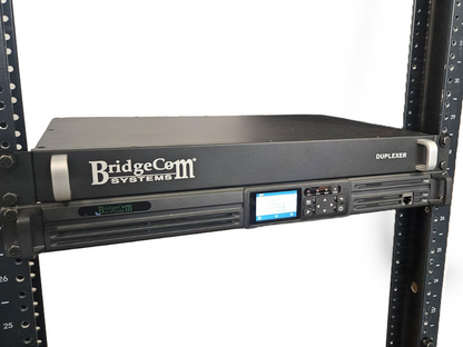 A black BDR-1550 (VHF) Analog/NXDN Repeater is rack-mounted with a duplexer, featuring a digital display and control buttons on the lower unit. This professional setup is Part 90 compliant for reliable communication needs.