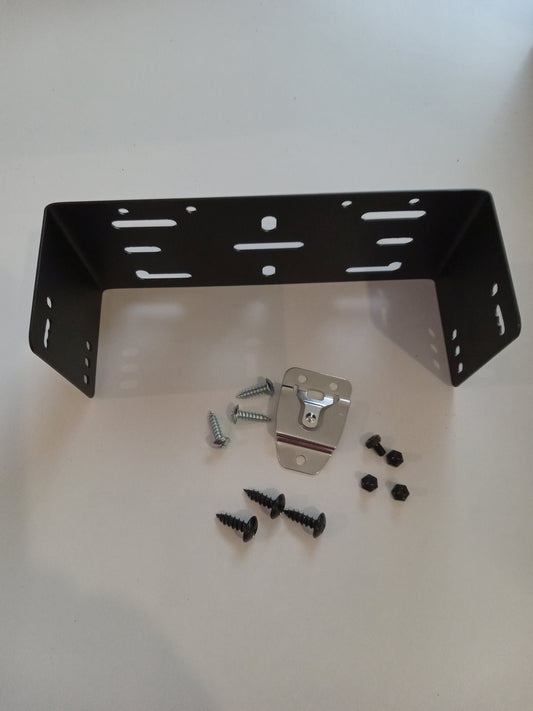 Displayed against a white background is the BCM Mounting Bracket with Hardware, designated as BCM-144. The black metal bracket features multiple holes and cutouts, and it comes with an assortment of screws, nuts, and a small metal piece with a curved slot.