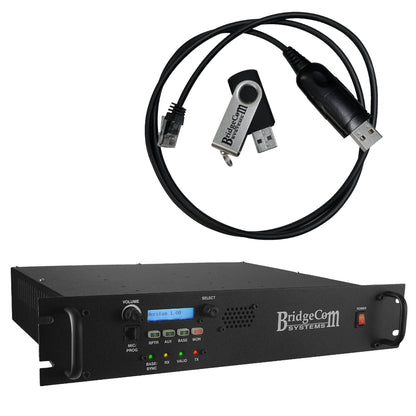 Displayed is the BCR-220 (220 MHz) Repeater MMDVM Digital package with a Programming Kit from BridgeCom Systems. The black, rack-mountable unit includes an array of buttons, an LCD screen, and indicator lights on its front panel, making it perfect for amateur ham radio enthusiasts. Positioned above it are a black USB cable and a USB flash drive featuring the BridgeCom logo.