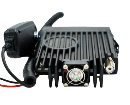 The AT-D578UVIII Plus Commercial Mobile Radio (GPS+BT) is a black, rectangular transceiver equipped with a coiled microphone, numerous ports, and a cooling fan on its front panel. It features a ribbed design for efficient heat dissipation and includes an antenna connector on the right side. This device supports DMR Repeater Roaming, enhancing its versatility in communication networks.