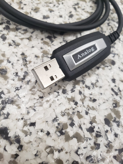 A close-up of a BridgeCom Buddy Programming Cable, labeled "Analog," resting on a speckled gray-and-white countertop—perfect for adjusting settings on your Buddy FRS handheld radio.