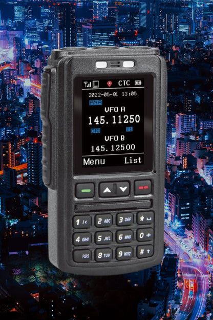 A black 578 Bluetooth Speaker Mic Programming Fee with various buttons and a digital display is shown against a nighttime cityscape of illuminated buildings and skyscrapers. The screen shows two frequency channels labeled "VFO A" and "VFO B" with respective numeric values, showcasing its compatibility with the advanced mobile radio system.