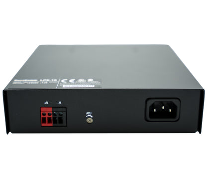 The Duracomm LPX-18BC Power Supply with Built-In Battery Charger features a black rectangular unit, with a three-prong AC input voltage socket on the right side and a red and black wire terminal block for DC output voltage on the left side. It also includes an "ADJ" adjustment knob conveniently located in the center. The top surface displays various certification logos and relevant text.