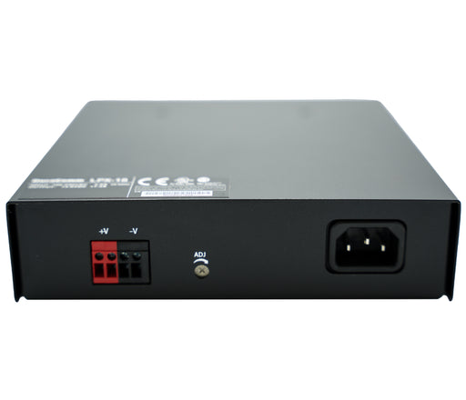 The Duracomm LPX-18BC Power Supply with Built-In Battery Charger features a black rectangular unit, with a three-prong AC input voltage socket on the right side and a red and black wire terminal block for DC output voltage on the left side. It also includes an "ADJ" adjustment knob conveniently located in the center. The top surface displays various certification logos and relevant text.